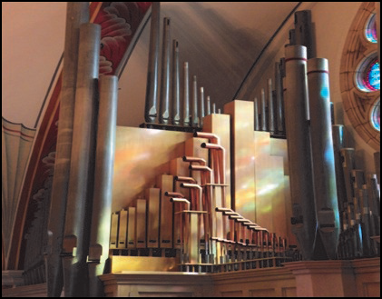 Pipe organ in a church, with various sizes of silver and copper pipes.