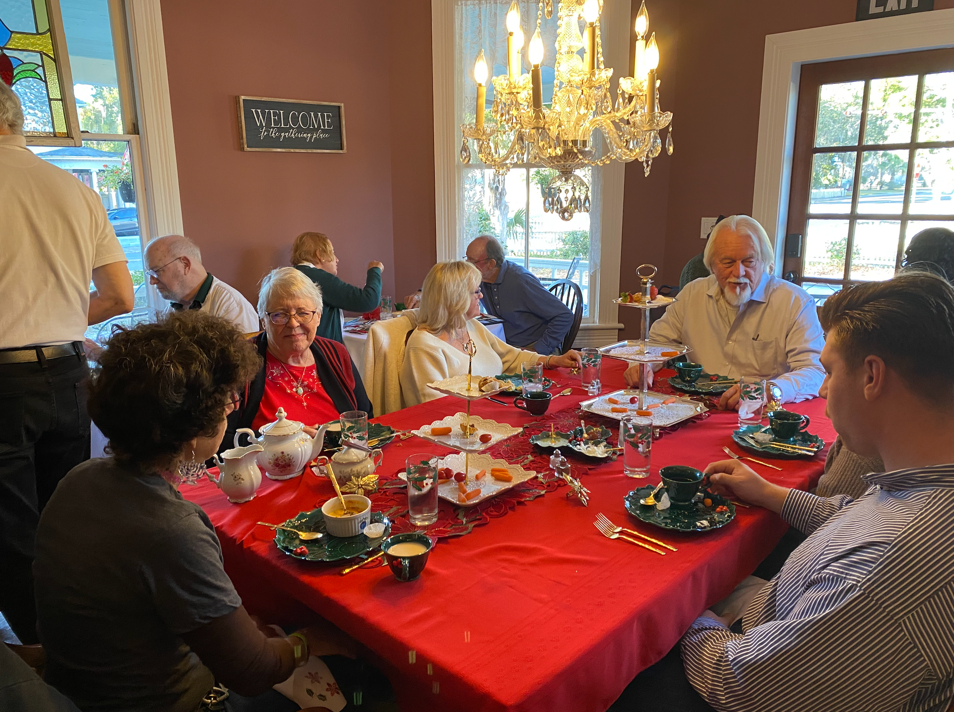 Holiday decorations and people enjoying afternoon tea in the dining room at The Camellia Rose Inn