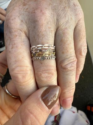 Close-up of a hand with stacked gold rings and a manicured thumbnail.