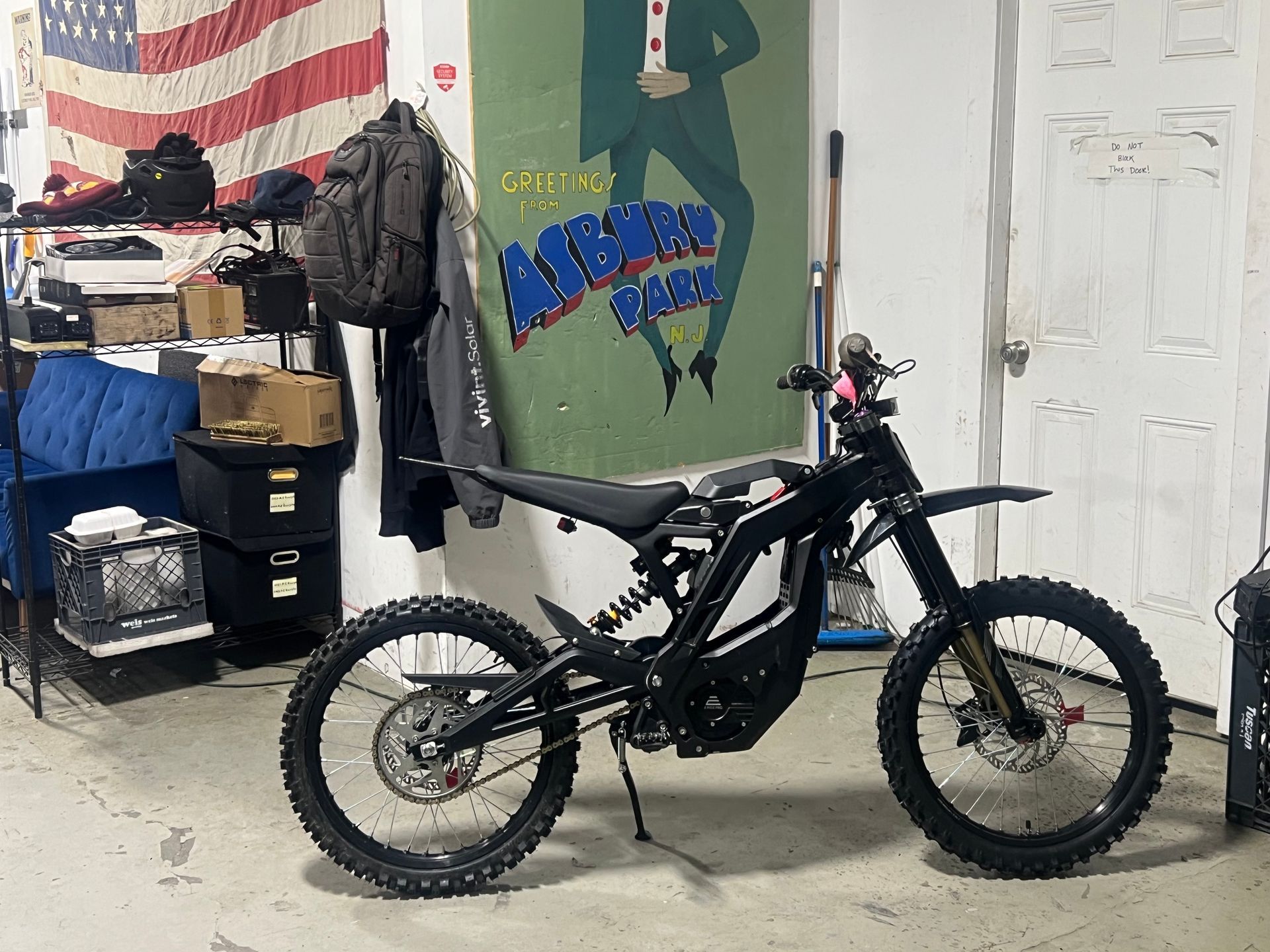 A dirt bike is parked in a garage in front of an american flag.