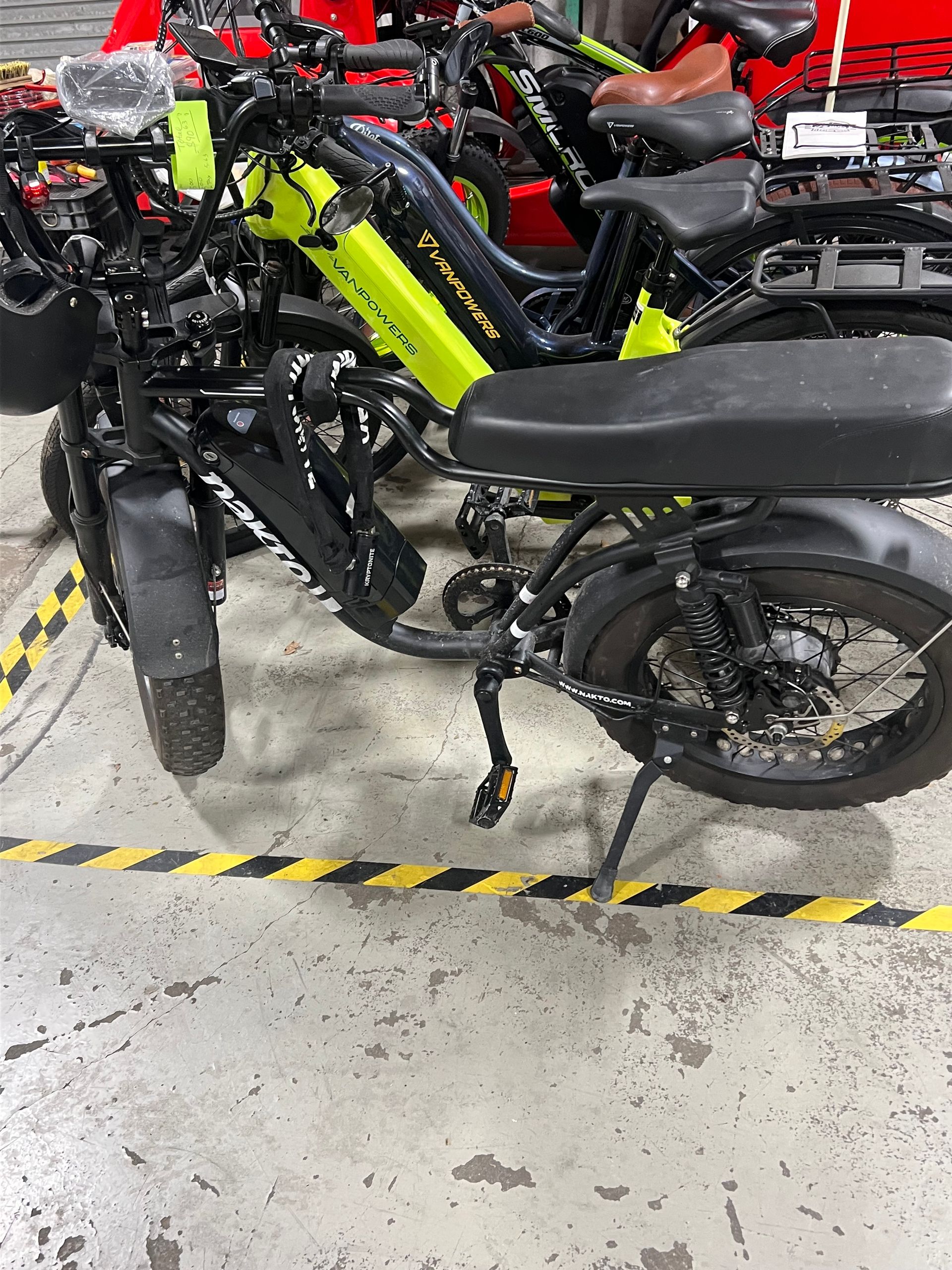 A row of electric motorcycles are parked in a garage.