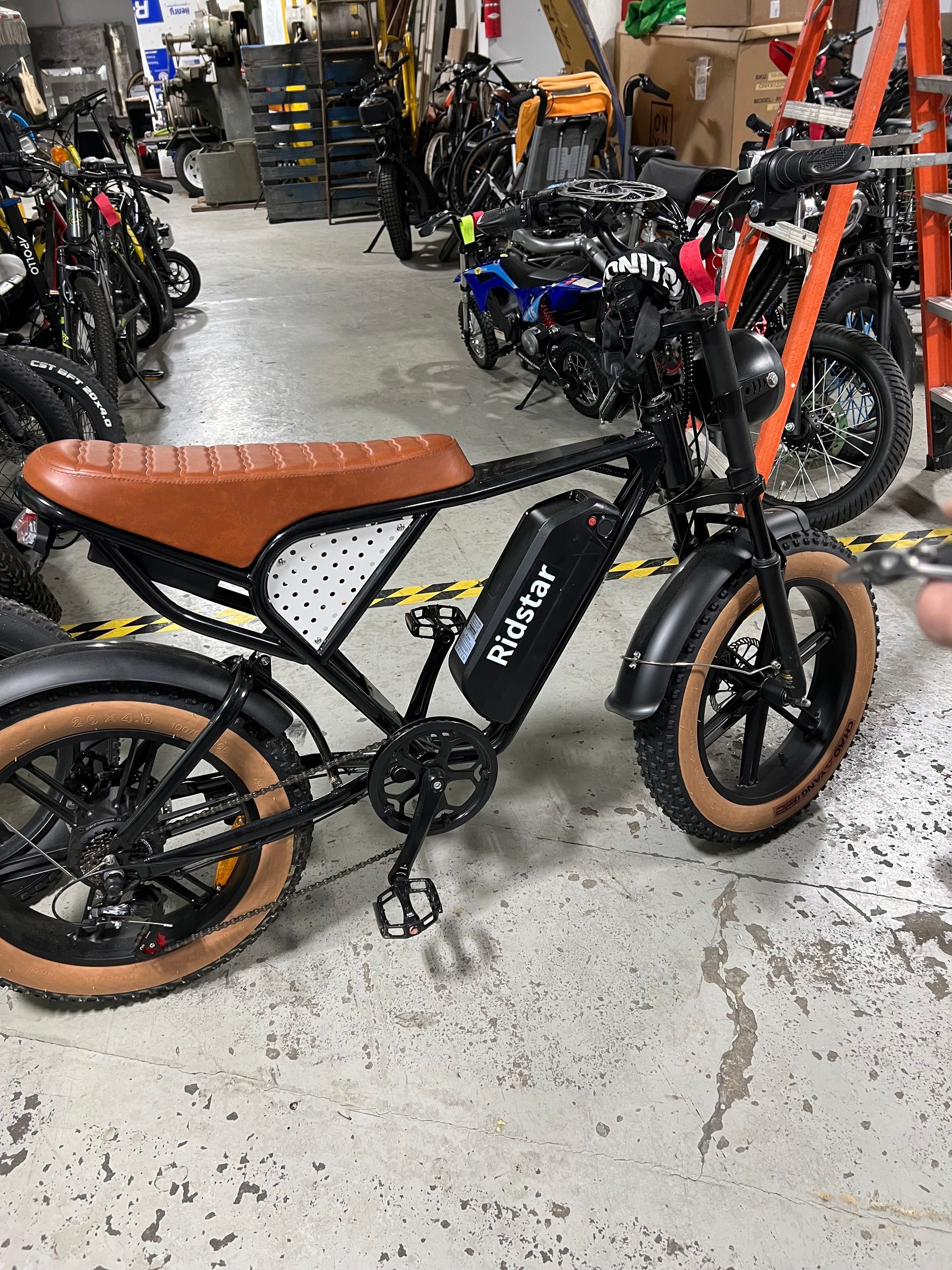A black and brown electric bike is parked in a garage.