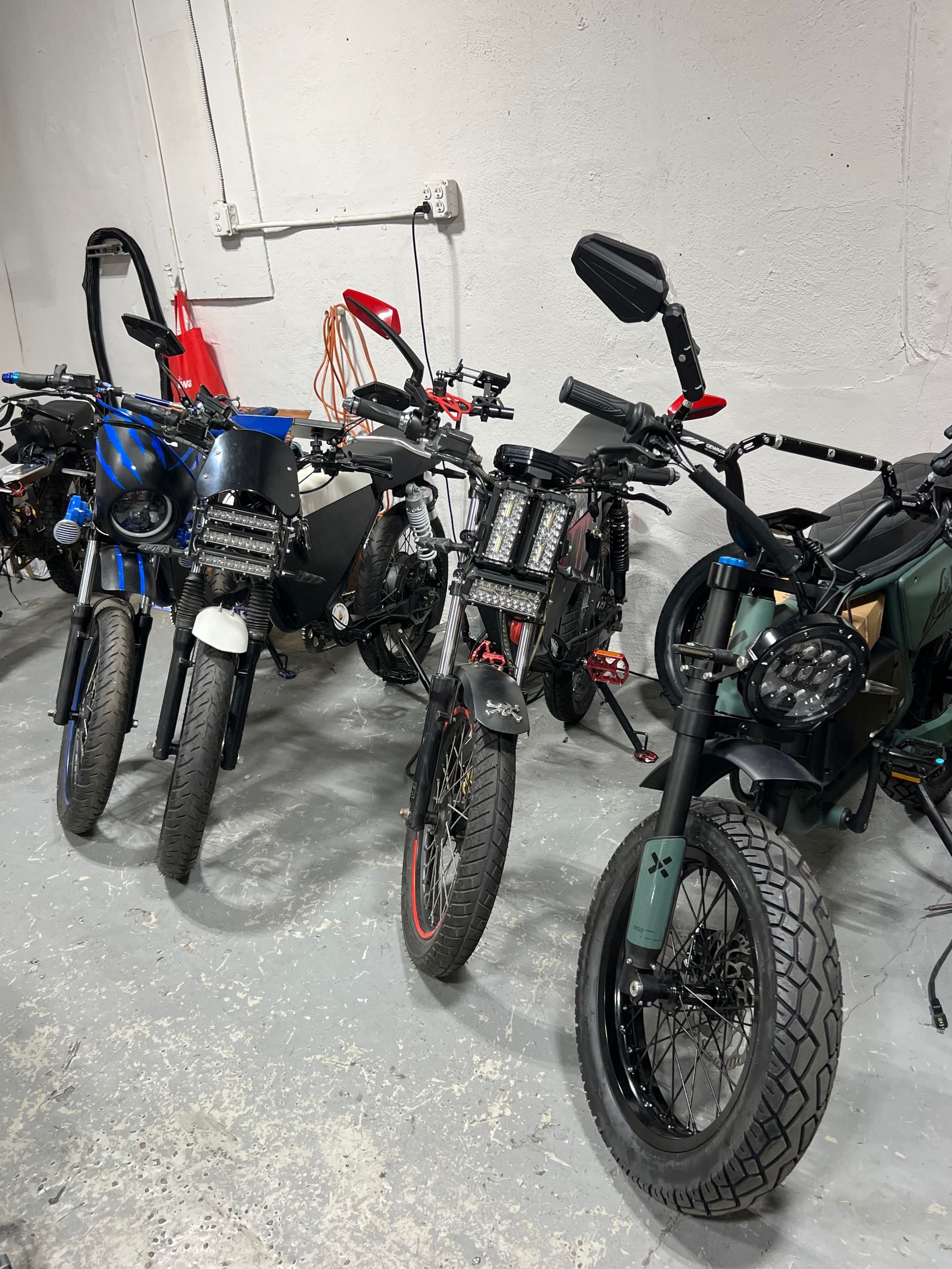A row of motorcycles are parked in a garage.