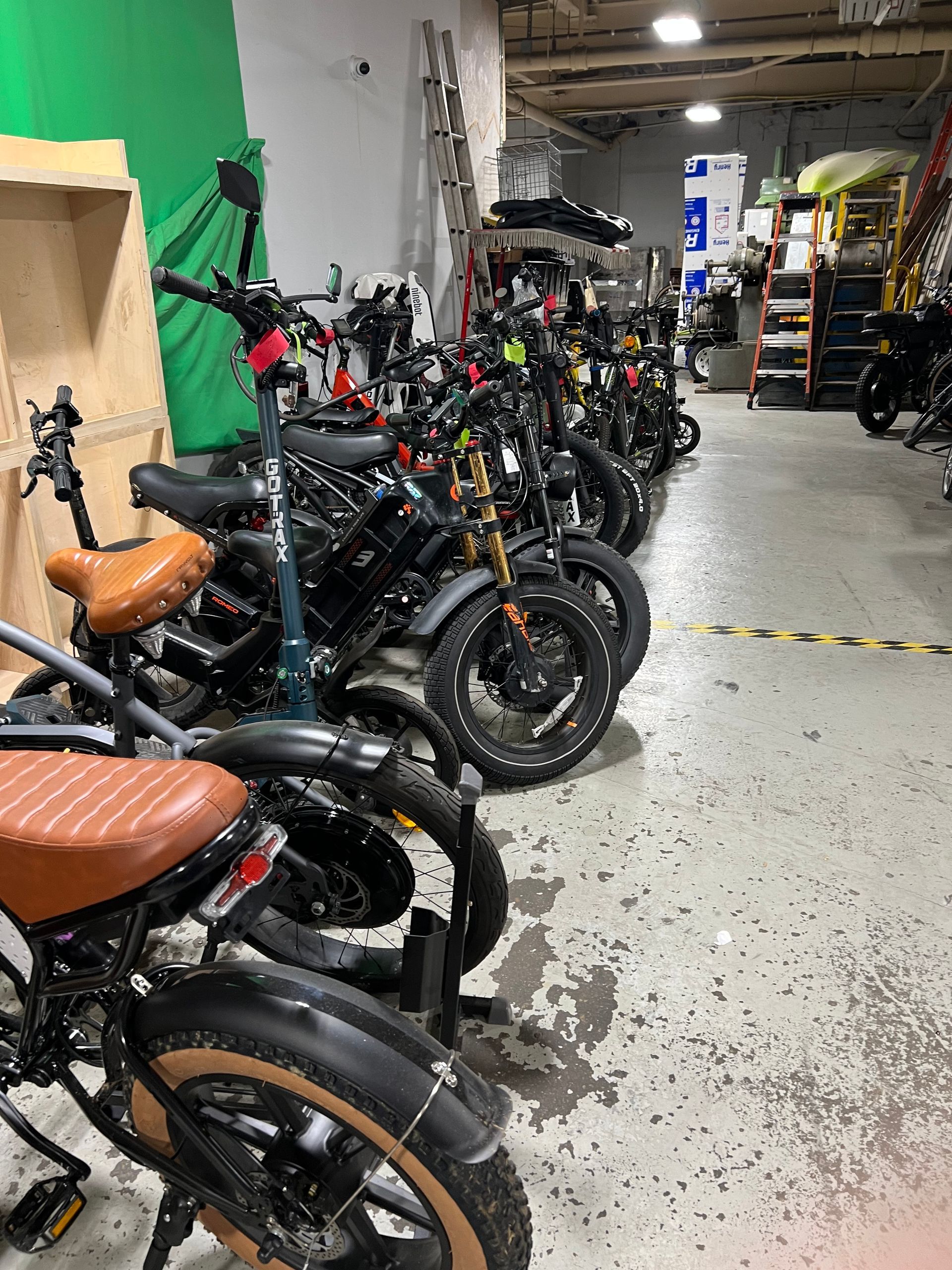 A row of motorcycles are parked in a garage.