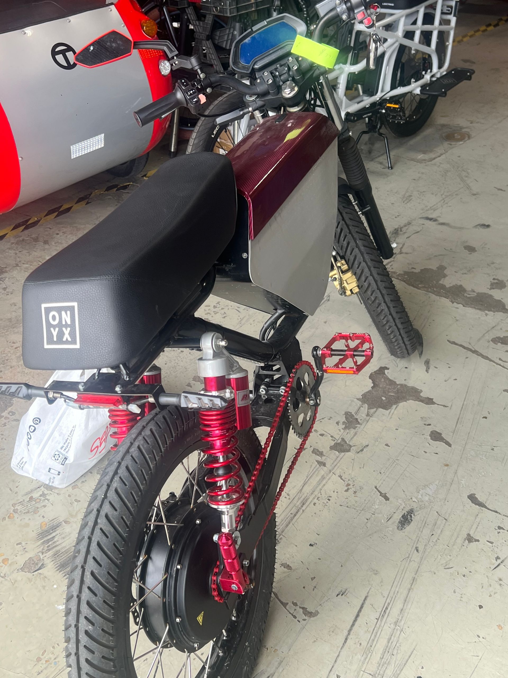 A motorcycle is parked in a garage with a sticker on the seat that says 06 y3