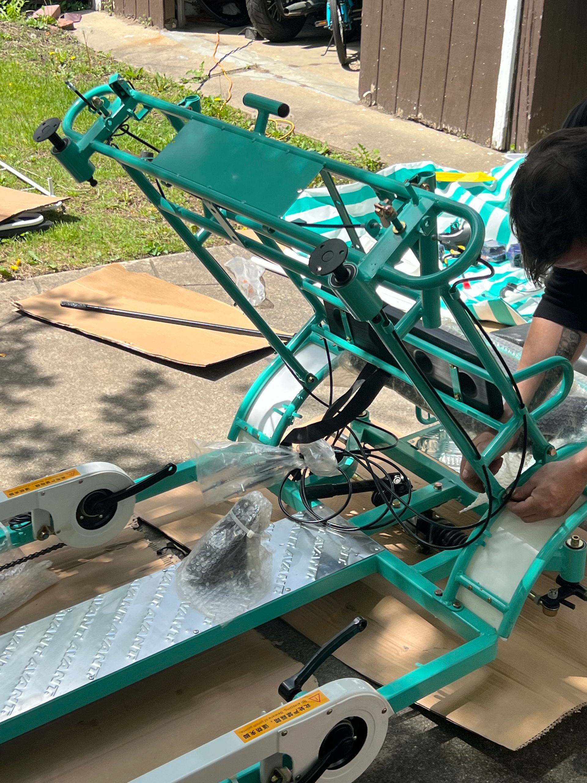 A man is working on a green bicycle frame.