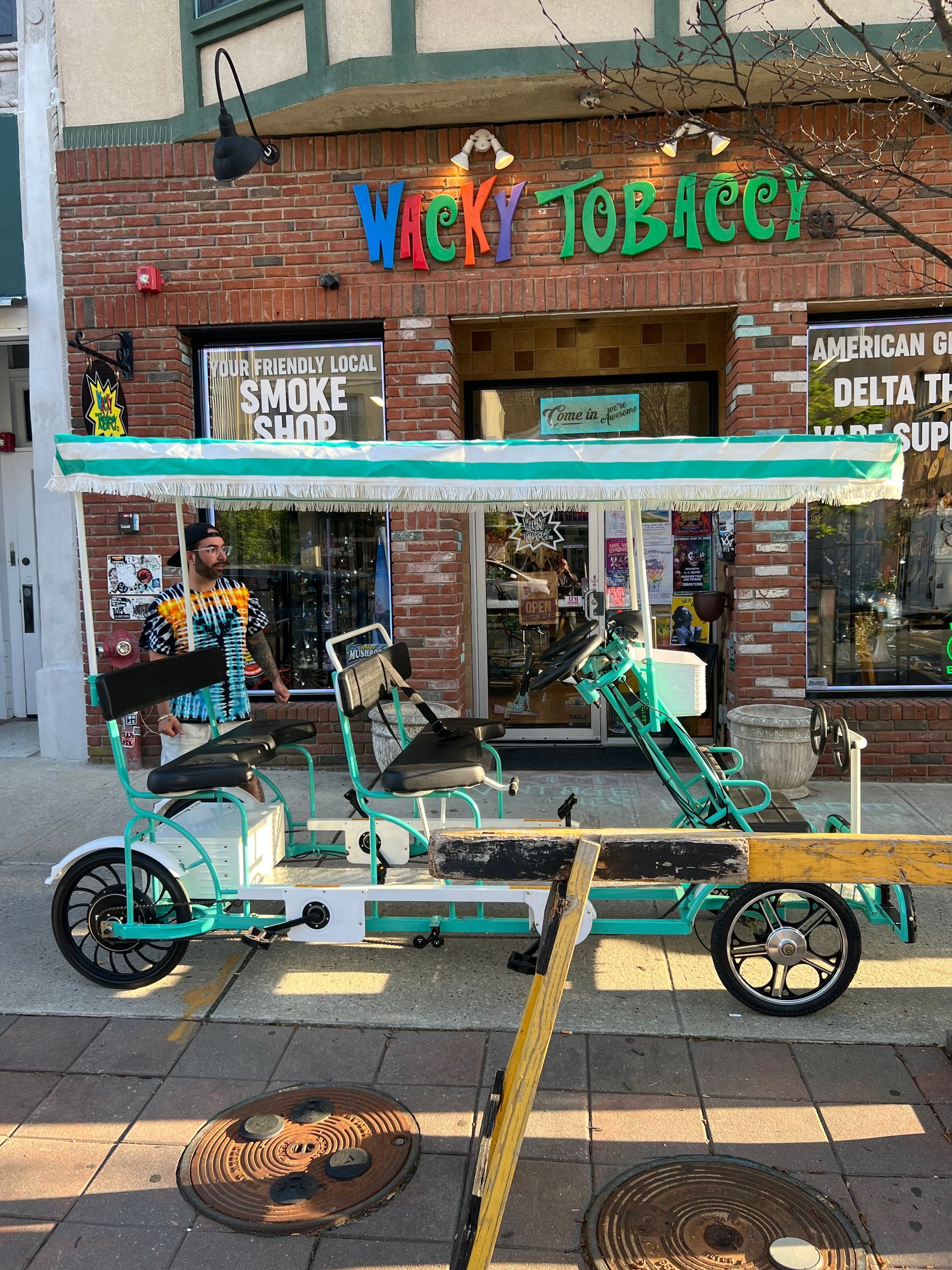 Two bicycles are parked in front of a tobacco store.