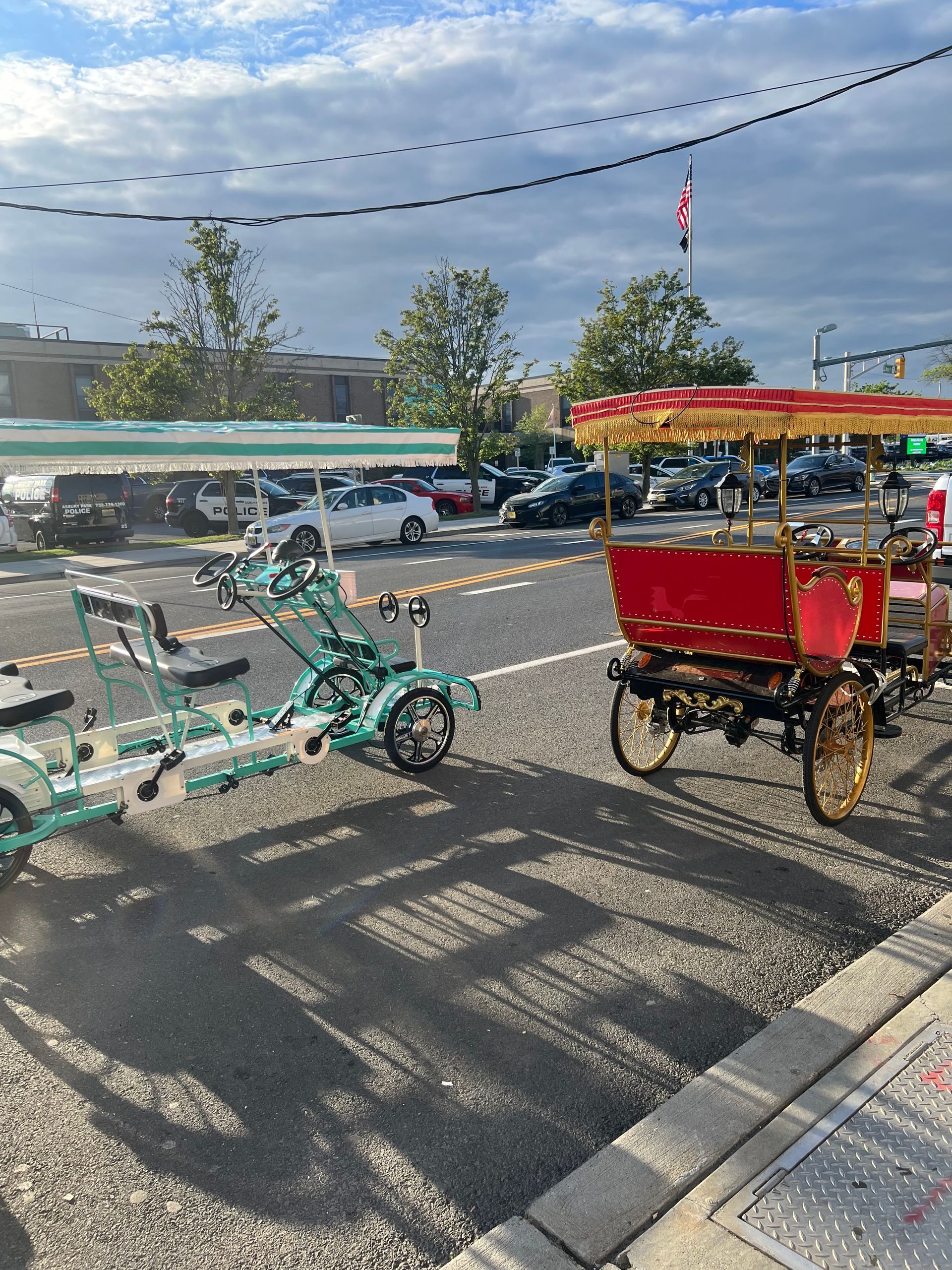 Two horse drawn carriages are parked on the side of the road.