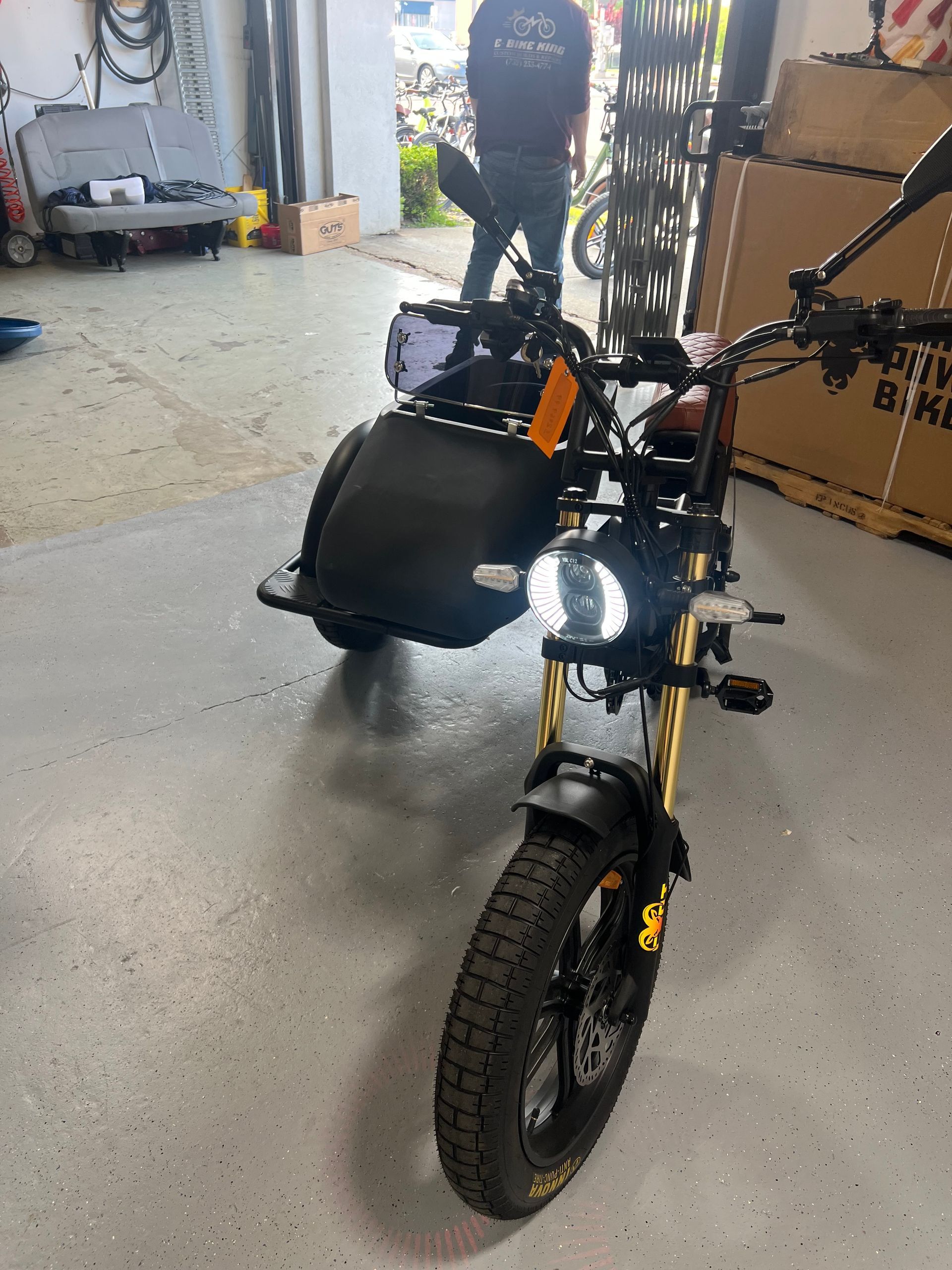 A motorcycle with a sidecar is parked in a garage.