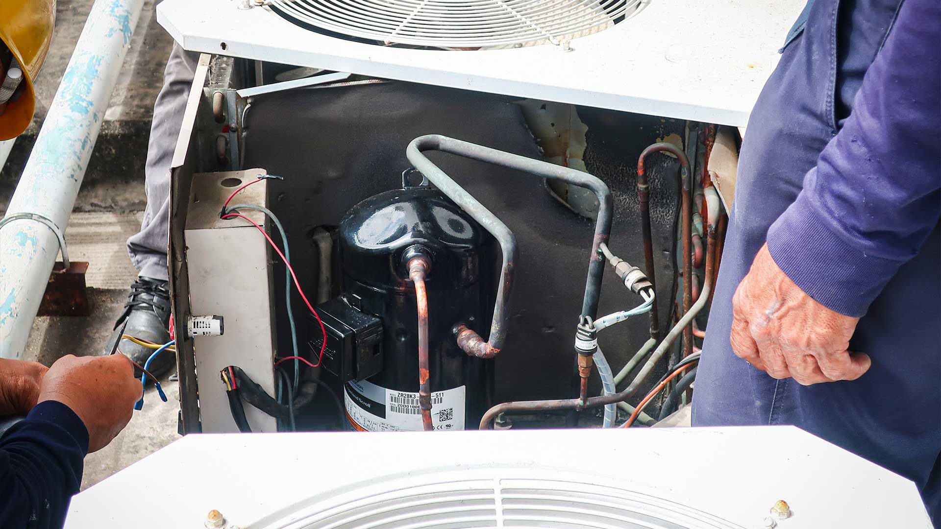 A man is working on an air conditioner.