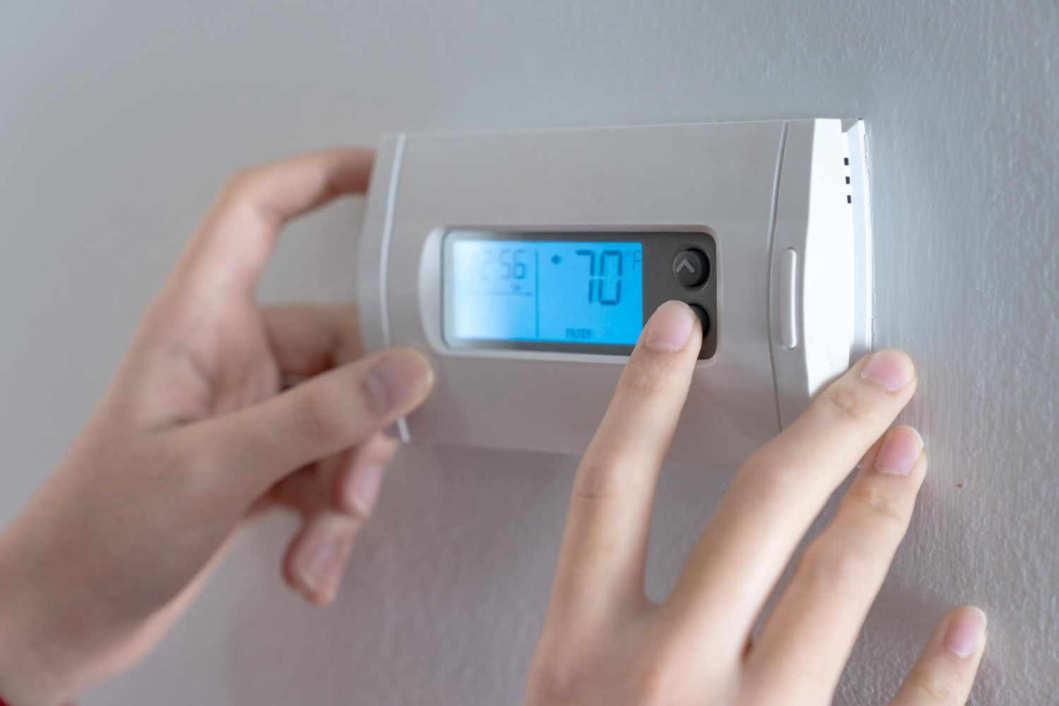 Hand Adjusting a Thermostat