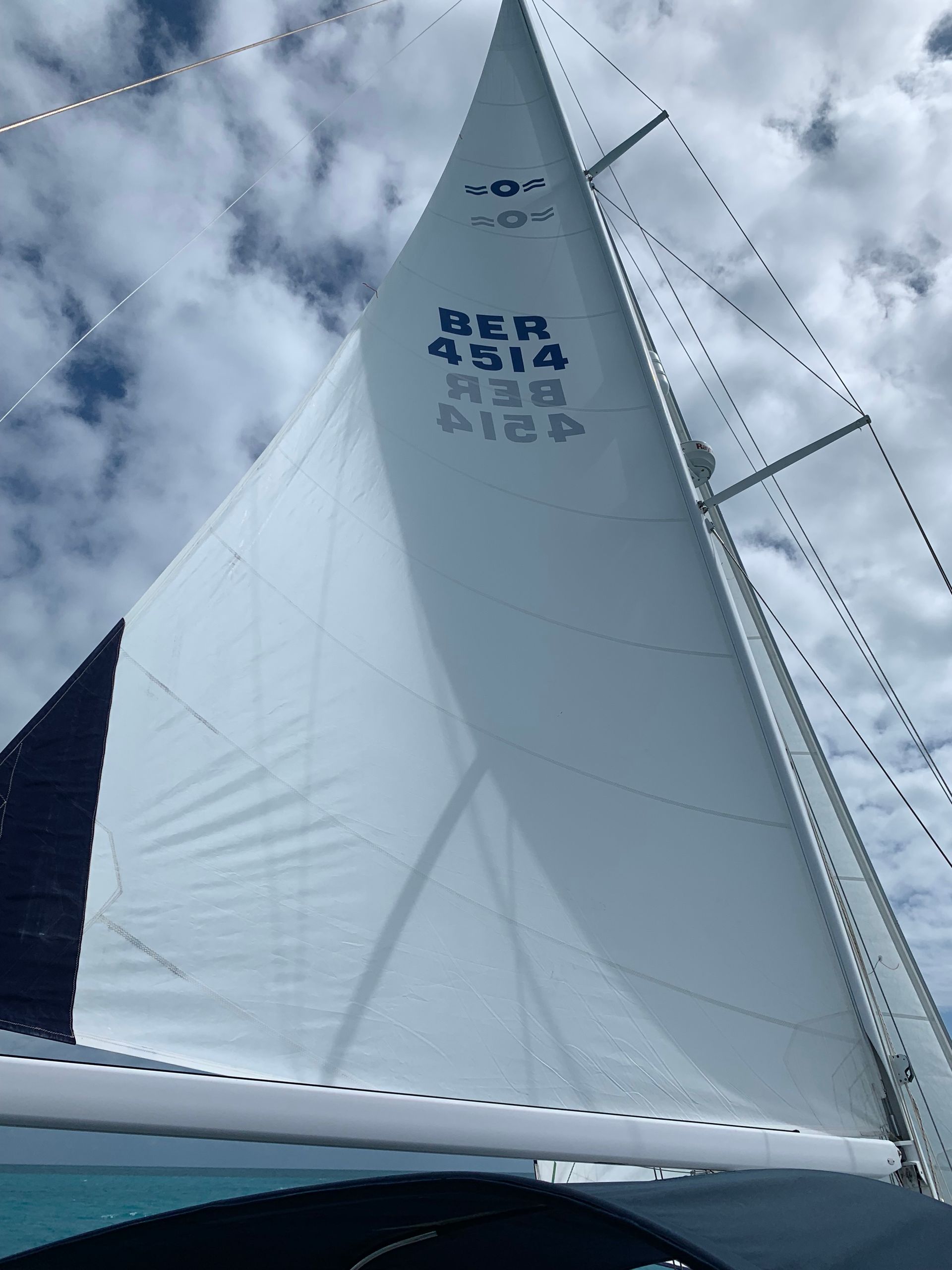 White sailboat sail against cloudy sky with Korean text printed on the sail