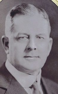 Portrait of a man in a suit and tie, gazing forward. Black and white photo.