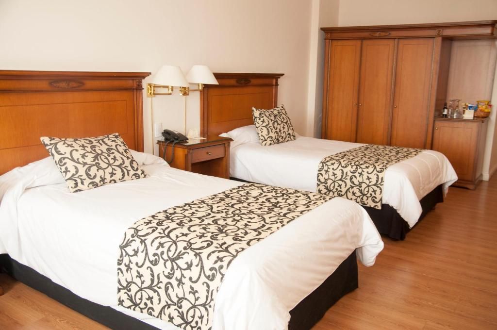 Habitación doble del Scala Hotel Buenos Aires con camas individuales y mobiliario clásico