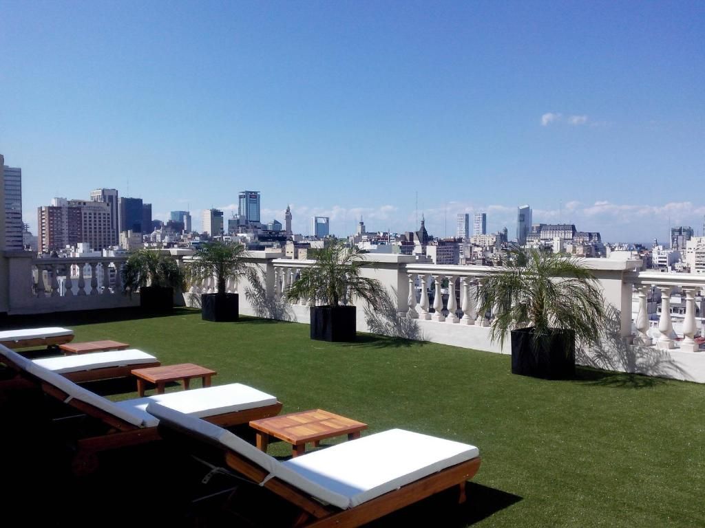 Terraza con césped artificial y palmeras del Scala Hotel Buenos Aires con vistas a la ciudad