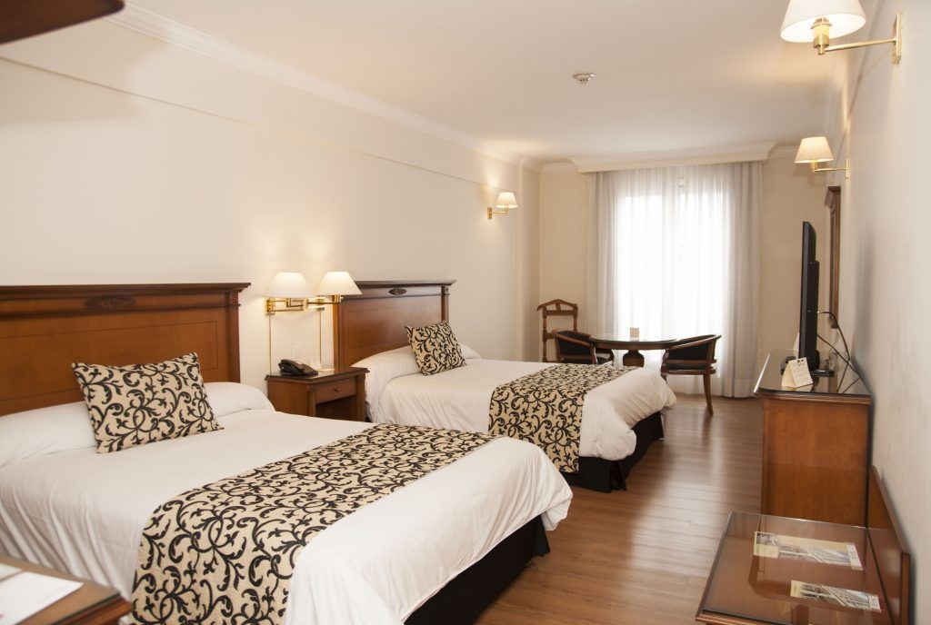 Una habitación de hotel con dos camas y un televisor