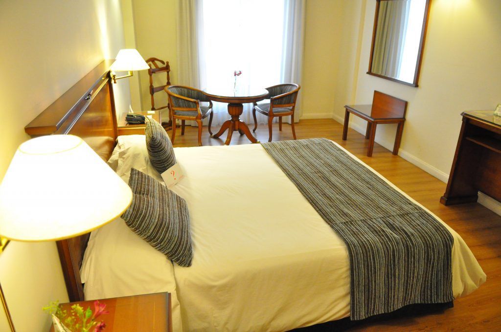 Una habitación de hotel con una cama king size, una mesa y sillas
