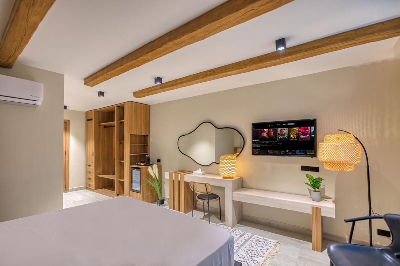 A hotel room with a bed , desk , chair and television.