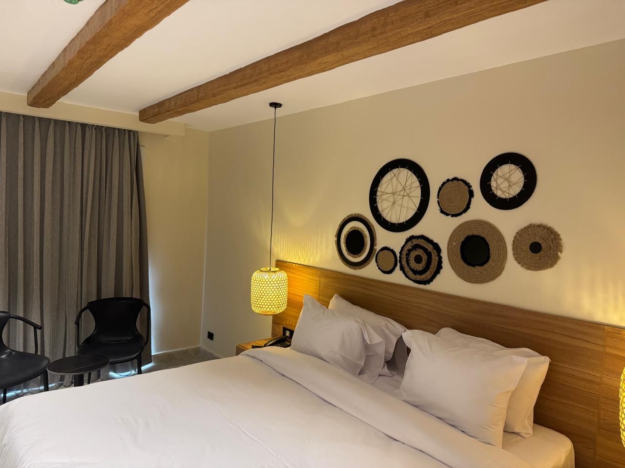 A hotel room with a king size bed and a chair.
