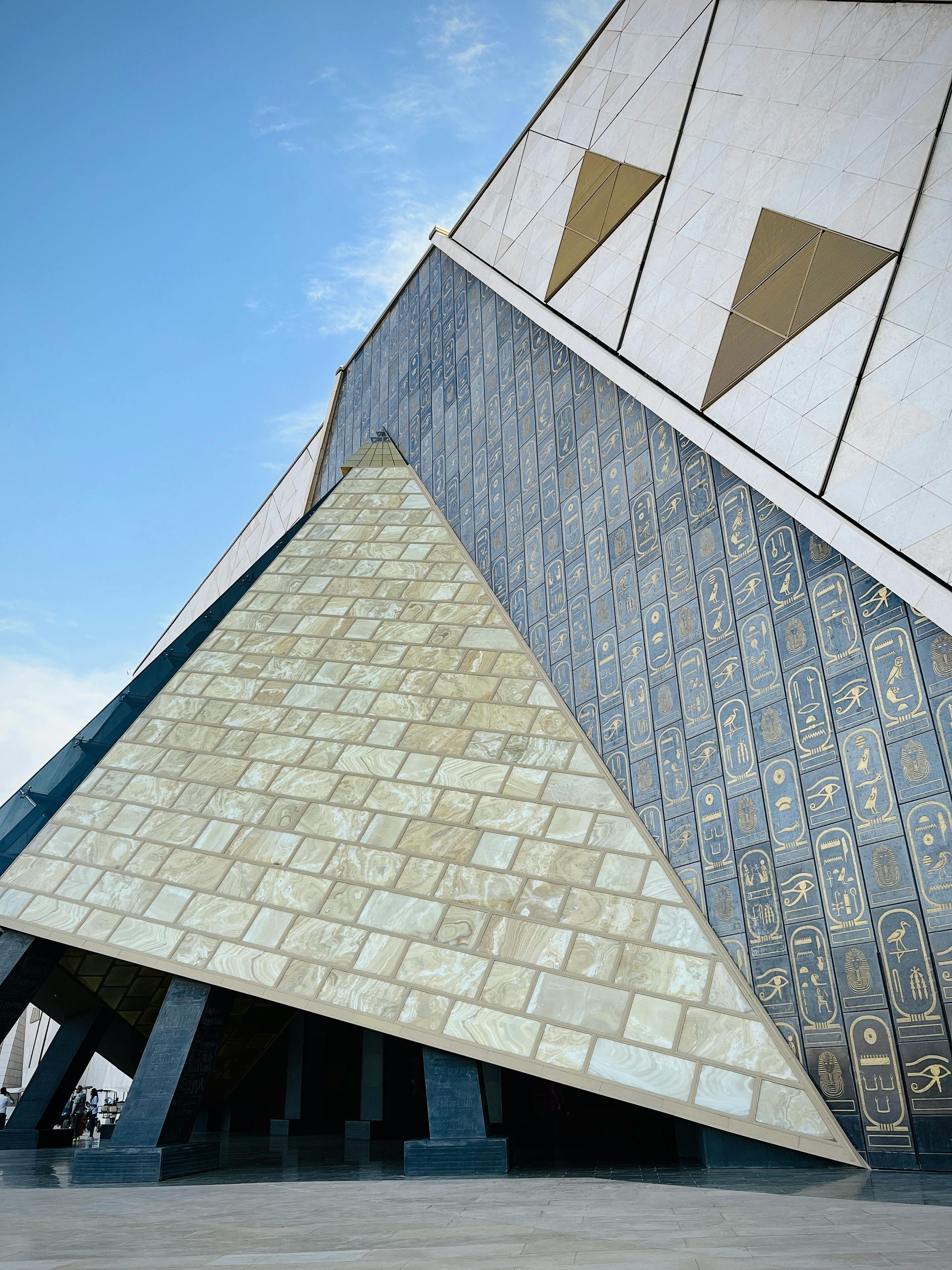 A pyramid shaped building with a blue sky in the background
