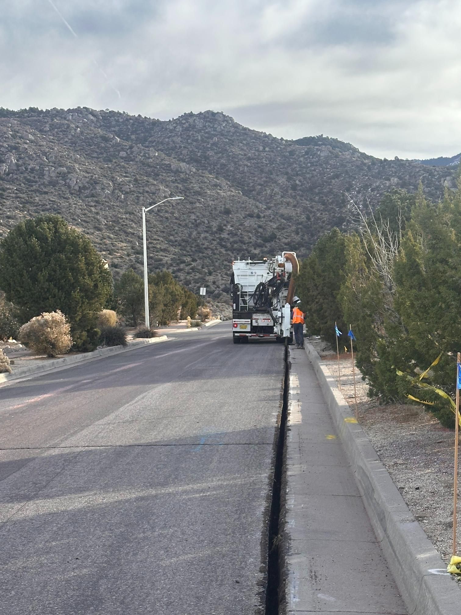 Road with a truck and traffic cones beside a mountain landscape under a clear sky