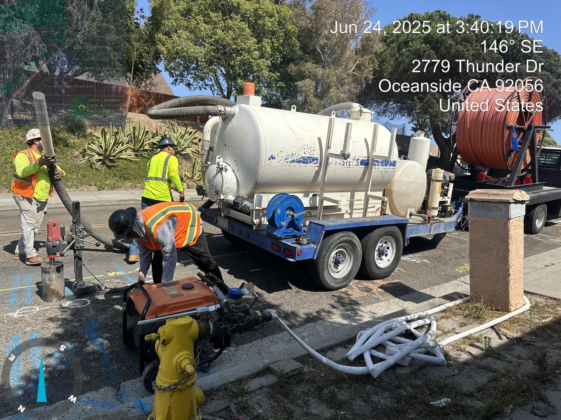 Roadwork crew around a cement mixer truck at a street construction site with cones and equipment