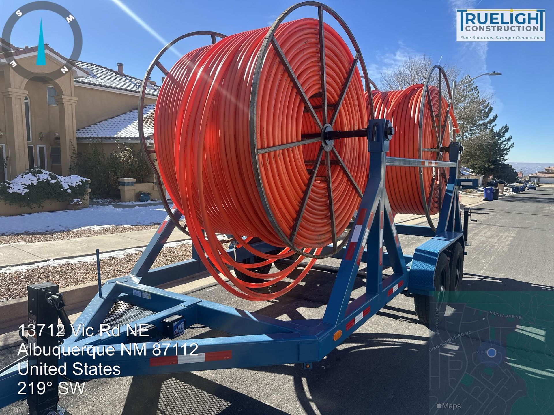 Large red hose reel trailer parked on a street in a snowy industrial area