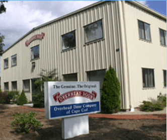 The Overhead Door Company of Cape Cod building with its sign in the foreground on a sunny day.