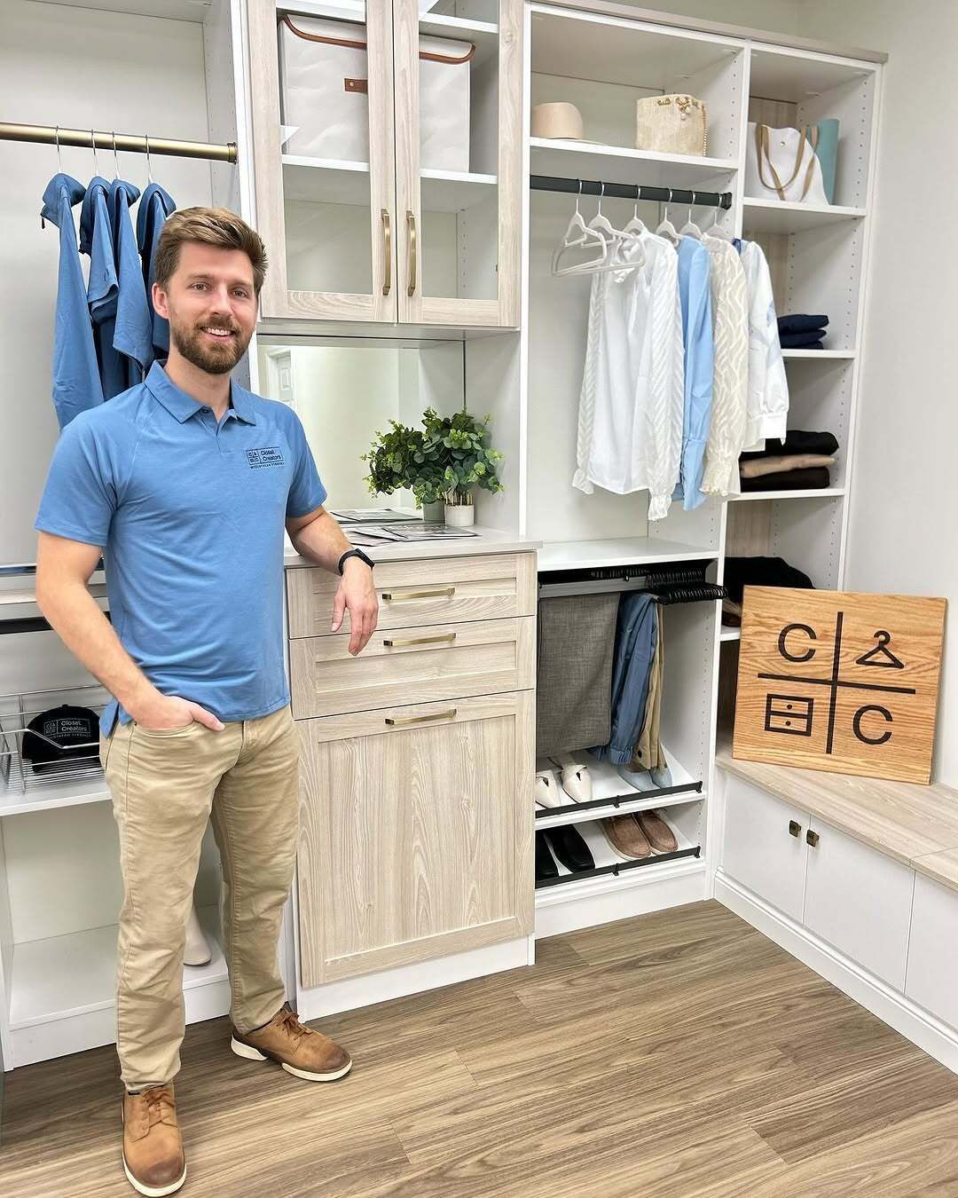 A walk in closet with white shelves and drawers and a window.