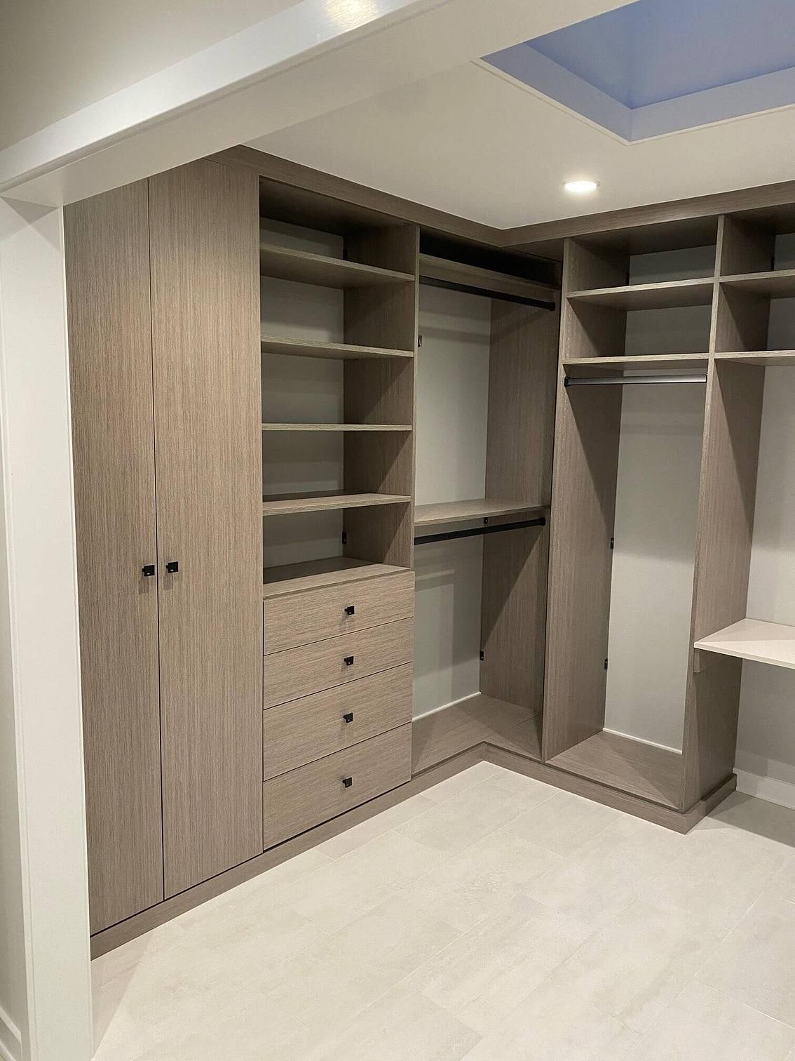 A walk in closet with lots of shelves and drawers.