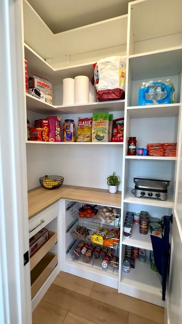 A pantry filled with lots of food and toilet paper.