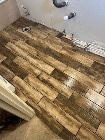 A bathroom with a wooden floor and a sink.