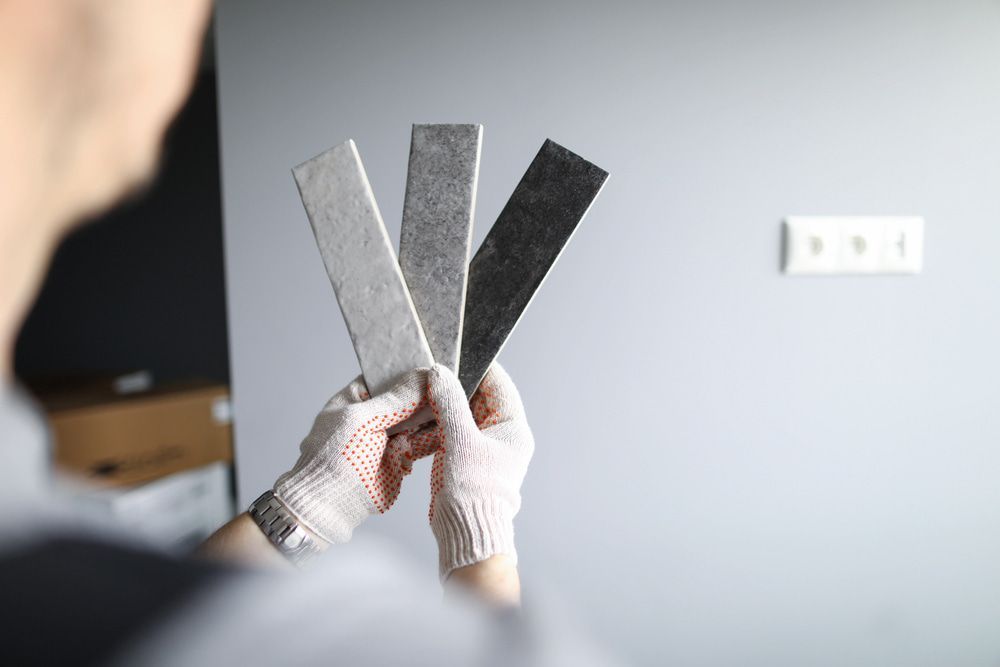 A Person Is Holding Three Pieces Of Tile In Their Hands — L & S Wirth Painting in Dubbo, NSW