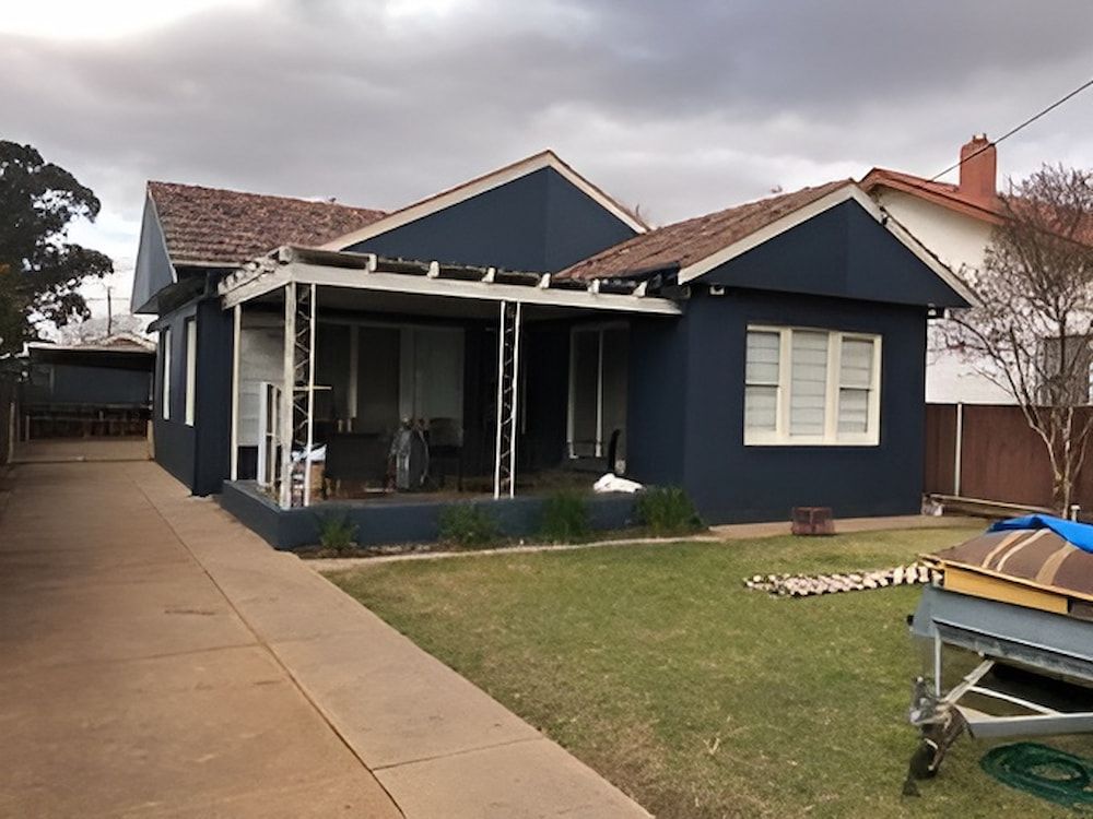 A Blue House With A Porch And A Boat In Front Of It — L & S Wirth Painting in Dubbo, NSW