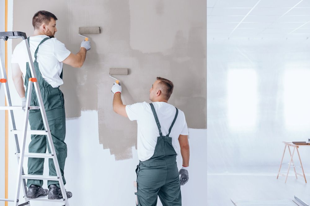 Two Men Are Painting A Wall In A Room — L & S Wirth Painting in Bourke, NSW