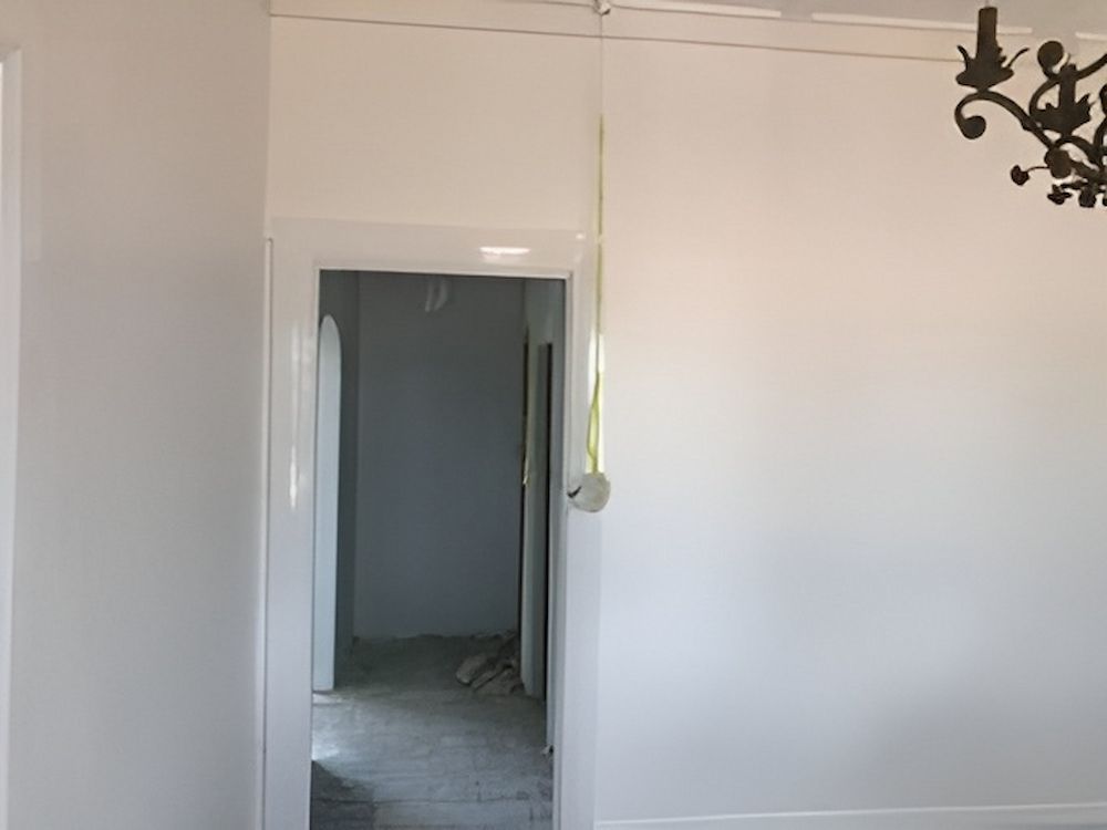 An Empty Room With White Walls And A Chandelier Hanging From The Ceiling — L & S Wirth Painting in Dubbo, NSW
