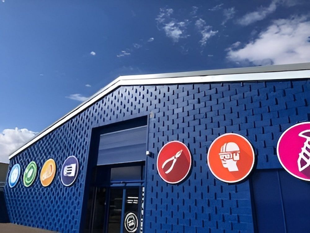 A Blue Building With A Bunch Of Signs On It — L & S Wirth Painting in Dubbo, NSW