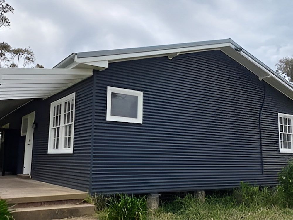A Small House With A Blue Siding And White Windows — L & S Wirth Painting in Dubbo, NSW