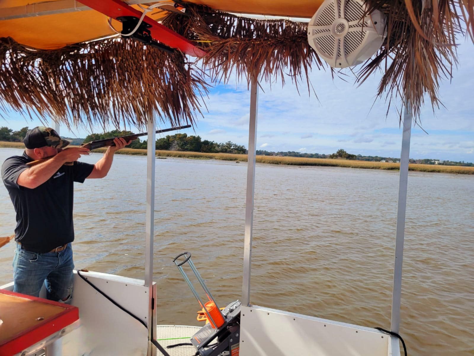 a guy on a boat with a shotgun