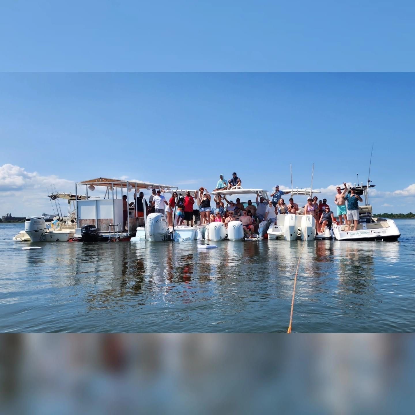 A group of people are standing on top of a boat in the water.