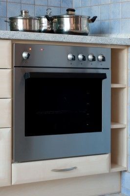 A stainless steel oven with pots and pans on top of it