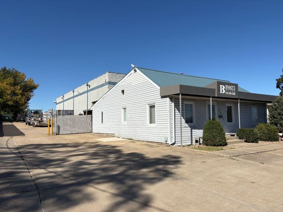 A small gray house with a water tower in the background.