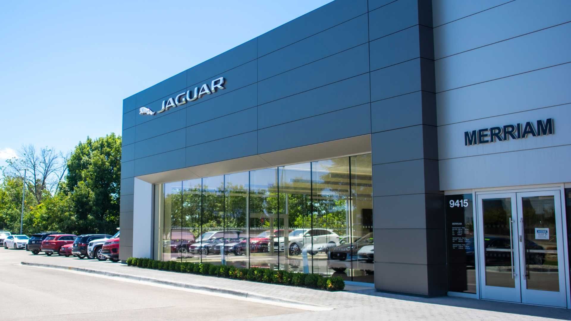 A car dealership with a lot of cars parked in front of it.