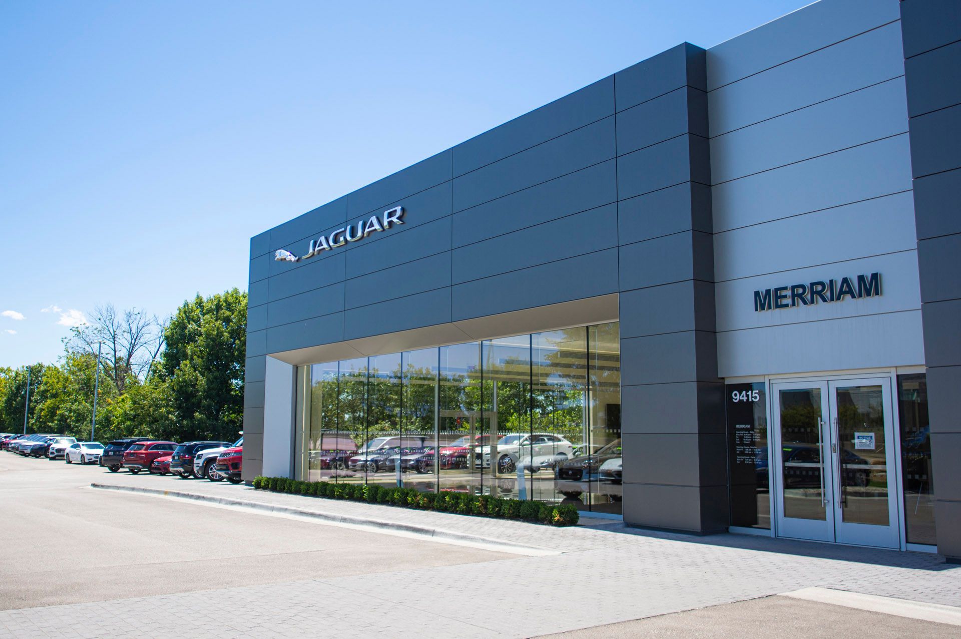 A jaguar car dealership with cars parked in front of it
