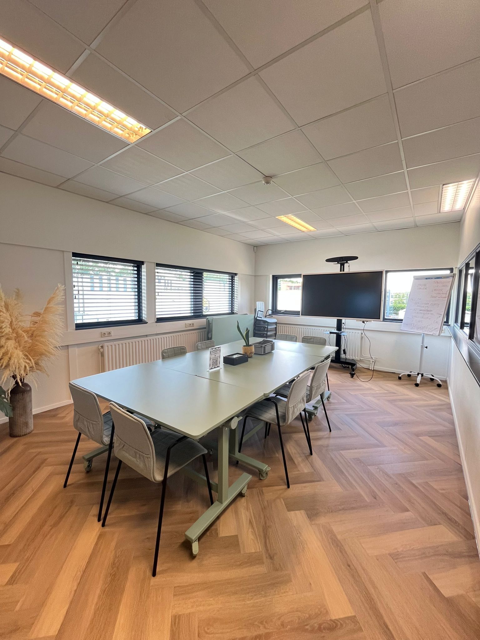 Een tafel met daarop drie microfoons en een koptelefoon