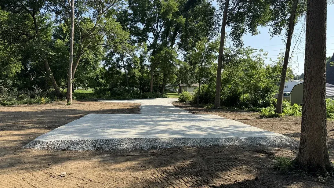 Concrete slab in a wooded area with trees and dry ground nearby
