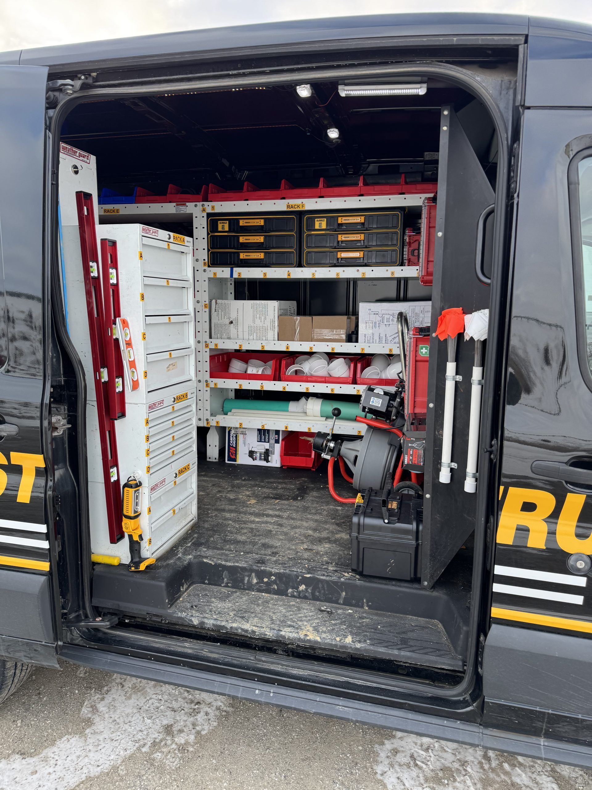 Open utility van with organized shelves, tools, and equipment inside the cargo area
