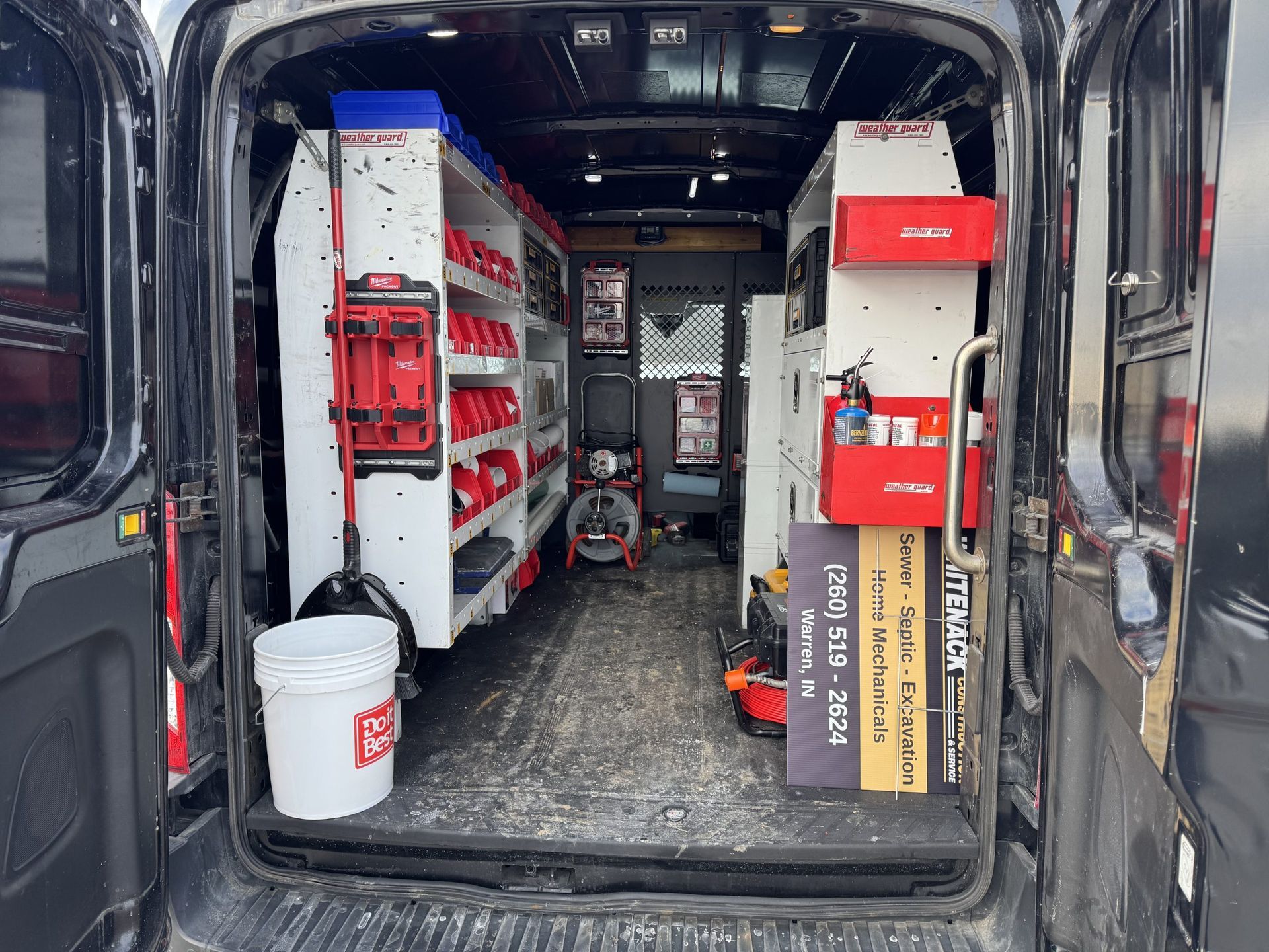Open van filled with organized tools, shelves, and equipment for a service or repair job