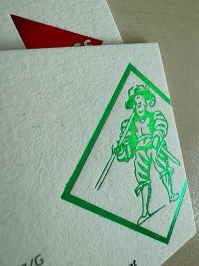 Grüne Strichzeichnung einer Figur in einer geneigten Raute auf einer weißen Karte vor rotem Hintergrund