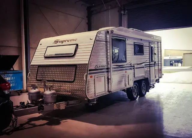 a supreme classic caravan is parked in a garage